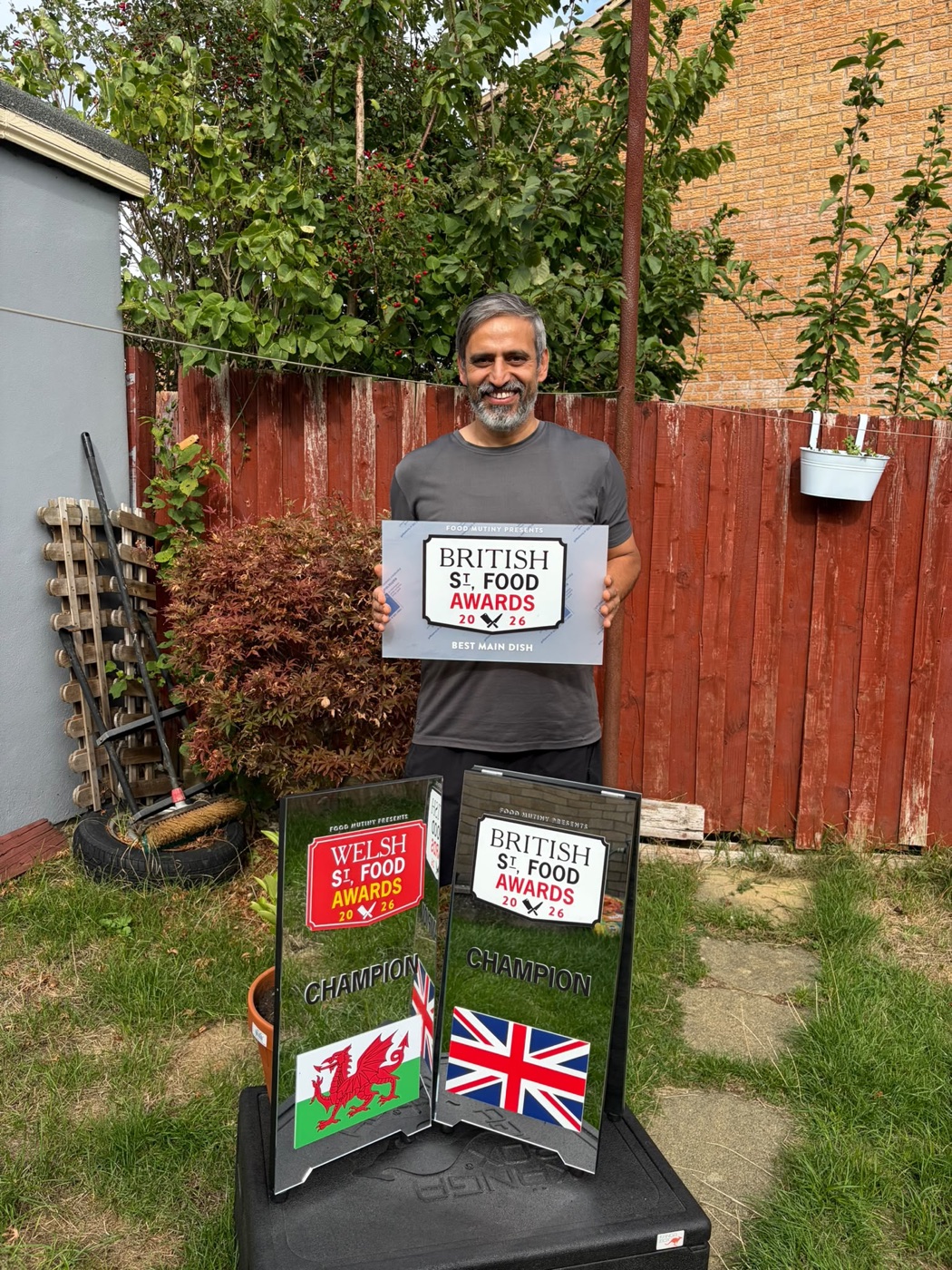 Kuldeep Singh holding the 2026 British Street Food Awards Best Main Dish sign, with the Welsh and British champion plaques